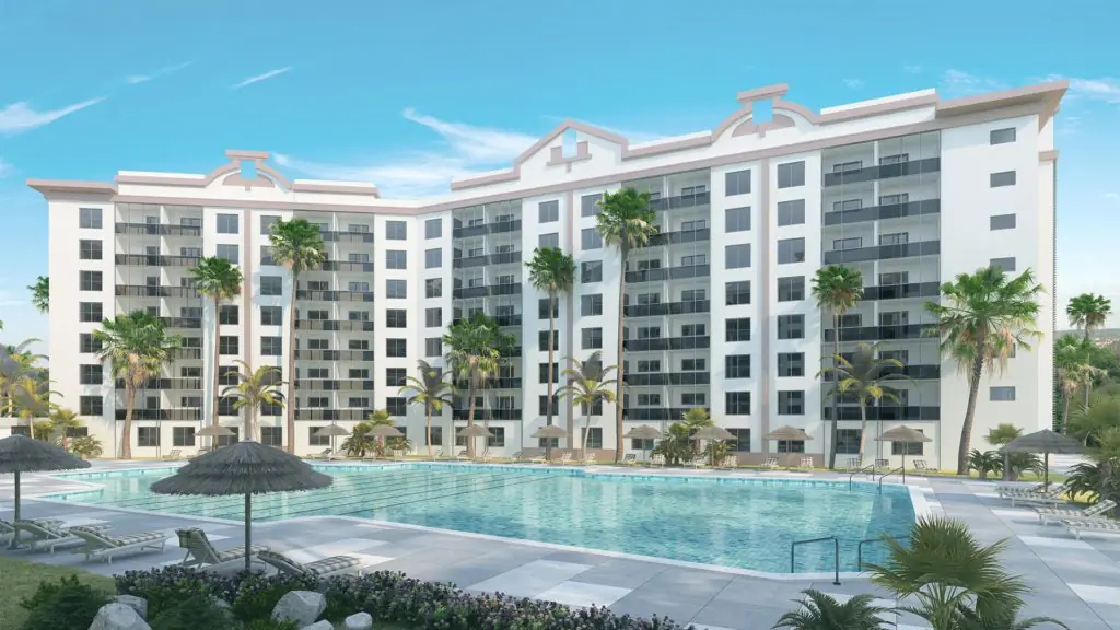Cabana Club multifamily community in Miami, FL with two 8-story white concrete buildings overlooking a resort-style pool, palm trees, and thatched cabanas