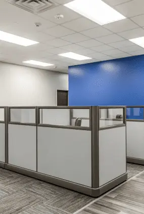 Workstation cluster at FSR Services with frosted glass cubicle panels and carpet tile flooring