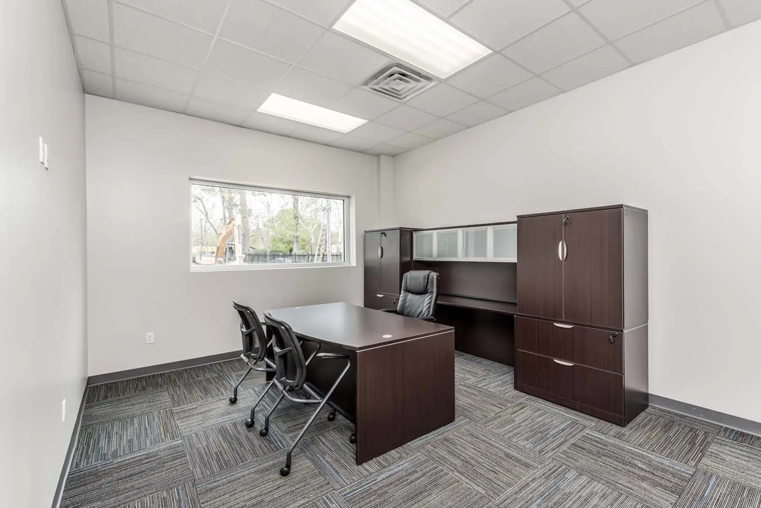 Private office at FSR Services with dark wood desk, credenza, and tall storage cabinets
