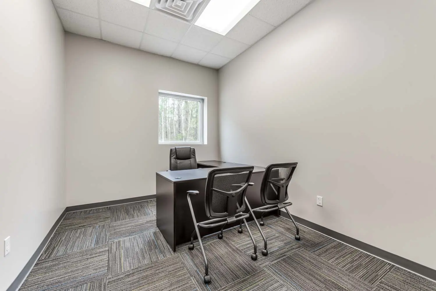 Private office interior at FSR Services with desk, guest chairs, and patterned carpet tile