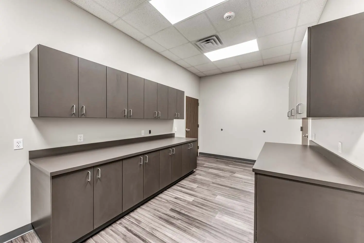 Storage and supply room at FSR Services with gray upper and lower cabinets and a long laminate counter