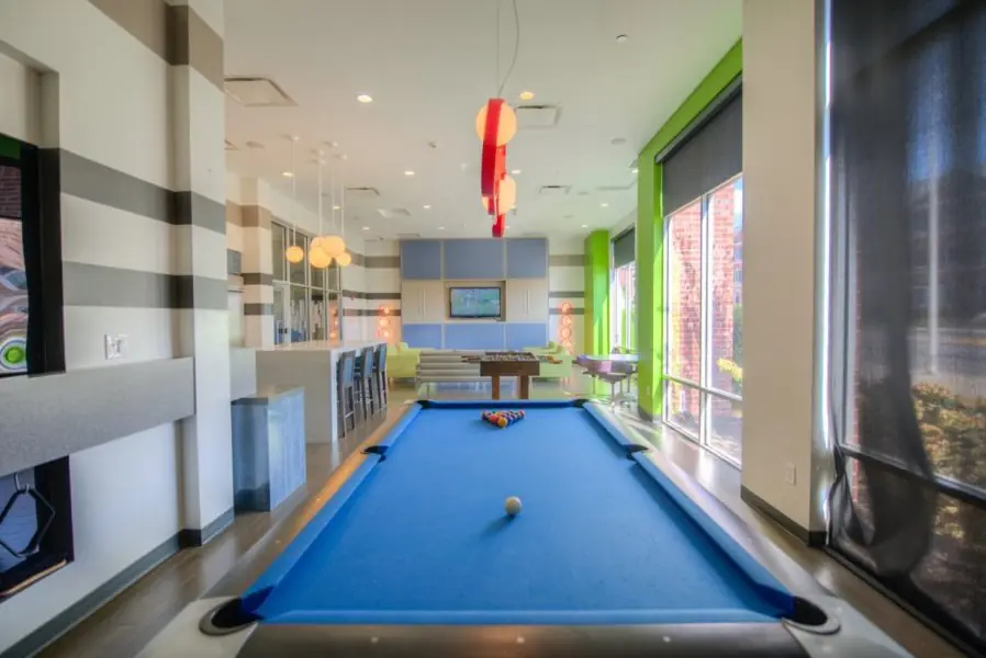 Resident game lounge at The Lex Student Housing in Lexington, KY with a blue-felt pool table, foosball, and lounge seating