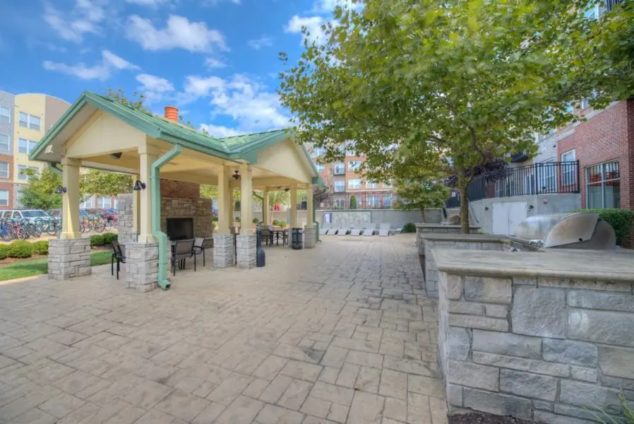 Outdoor amenity pavilion at The Lex Student Housing with covered seating, fireplace, and built-in grilling stations