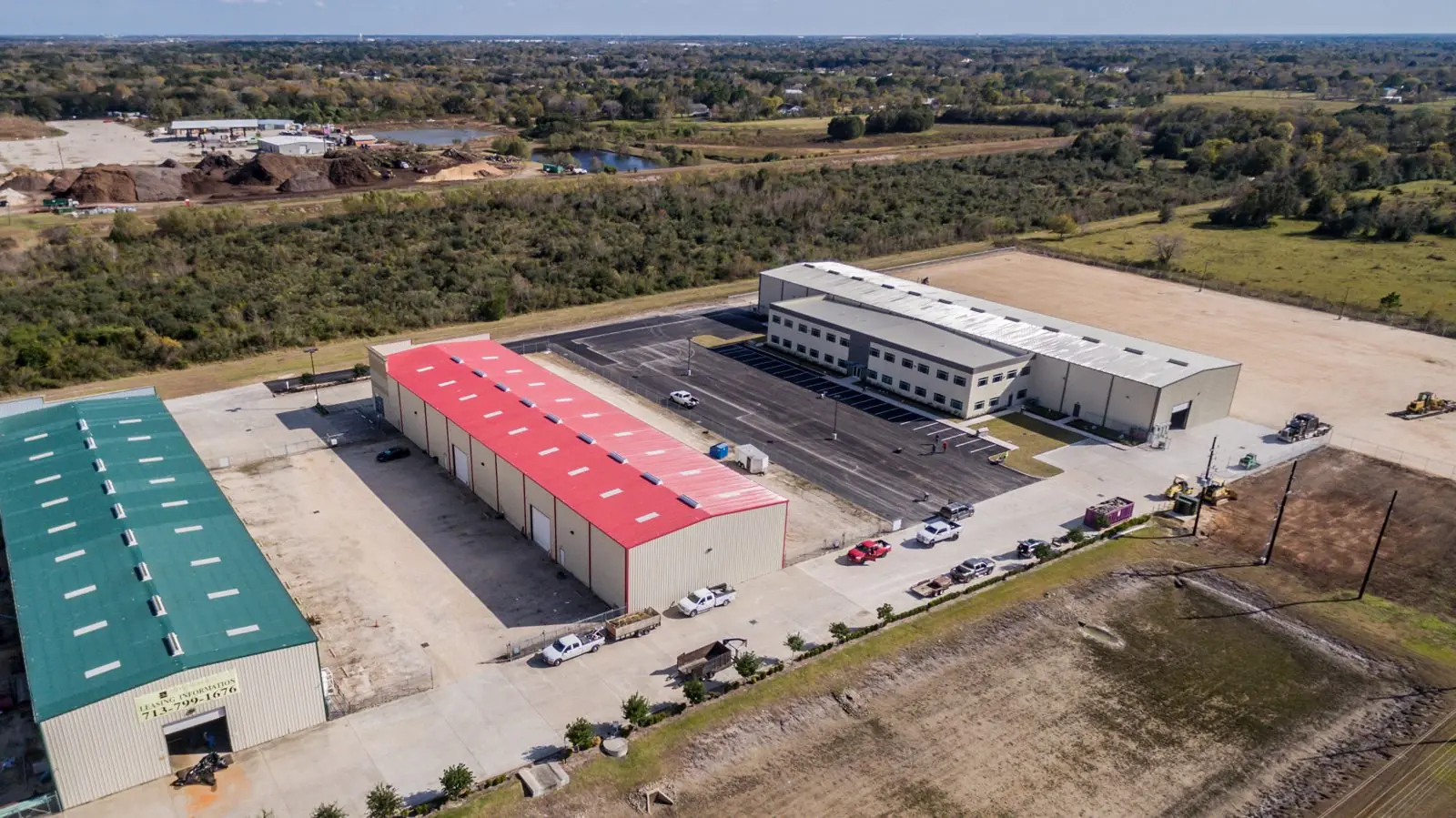 Aerial context view of the Repcon Industrial campus alongside neighboring red and green flex warehouse buildings in Houston, TX