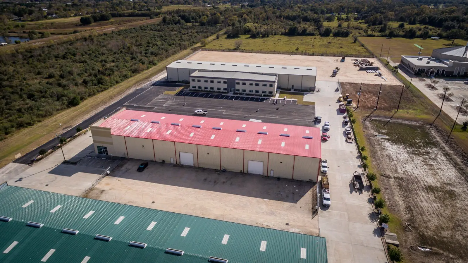 Aerial of the Repcon Industrial site looking across the parking yard toward the office and warehouse facility with neighboring industrial buildings in the foreground