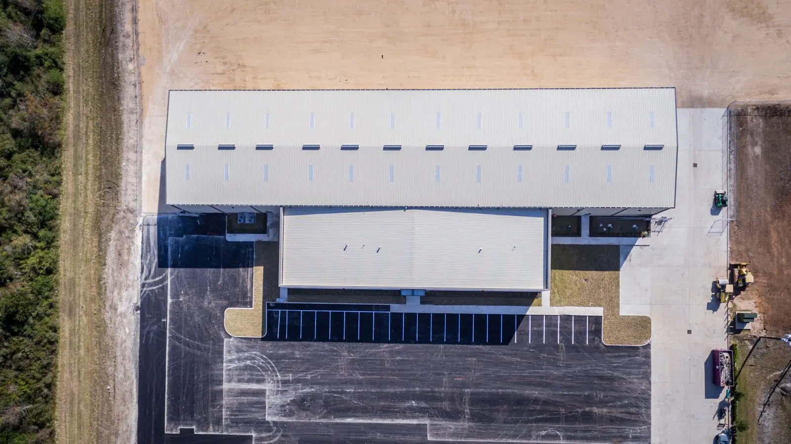 Top-down aerial of the Repcon Industrial warehouse and office wing showing the building footprint, roof penetrations, and main entry parking