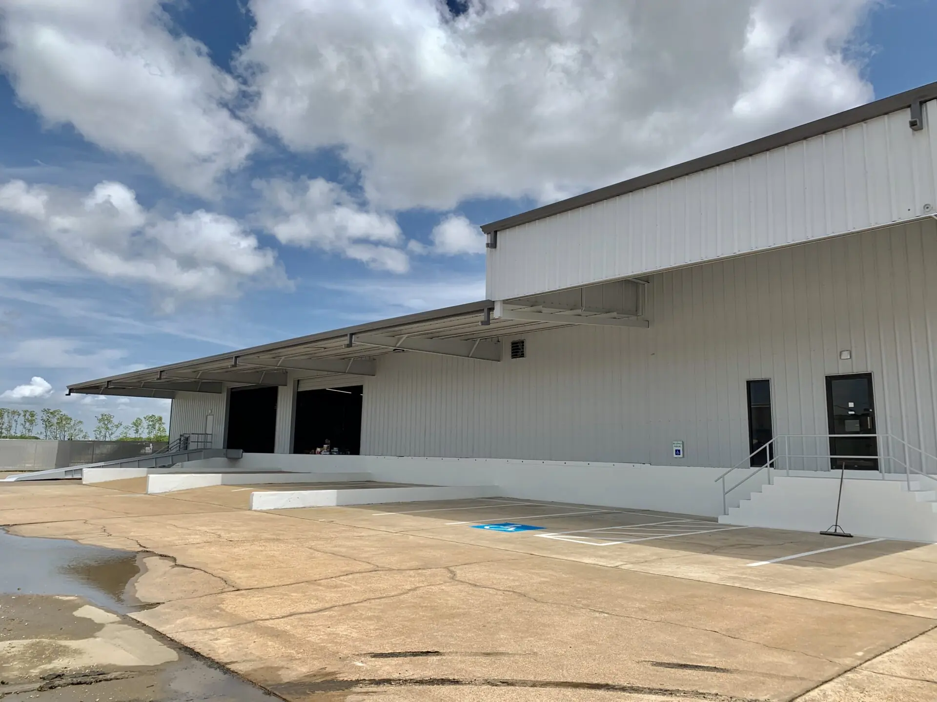 Covered loading dock and accessible ramp at Summit Industrial's La Porte facility with metal siding and overhead canopy