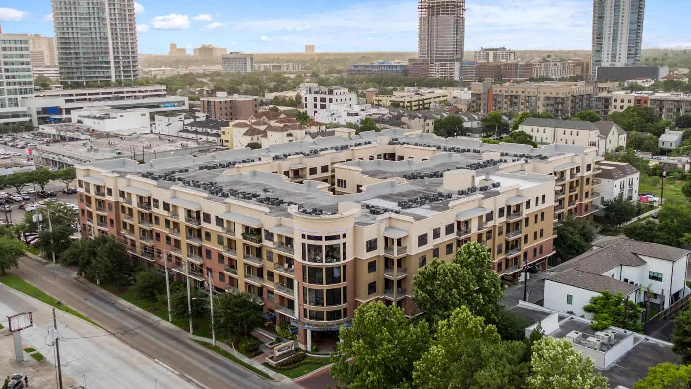 Aerial view of Upper Kirby Apartments in Houston, TX showing the full mid-rise footprint with the Galleria-area skyline in the background