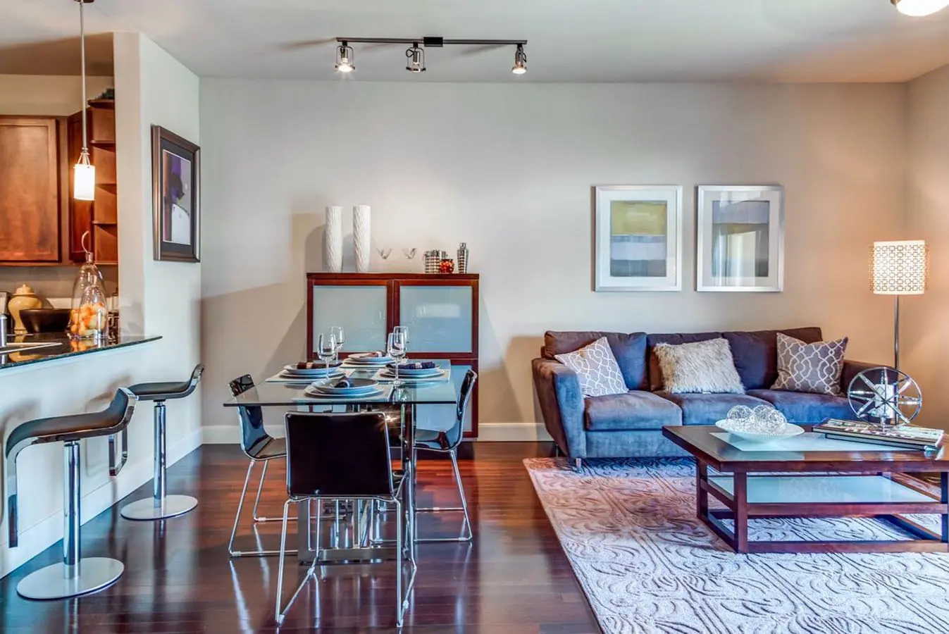 Open-concept apartment interior at Upper Kirby Apartments with a kitchen breakfast bar, dining room, and living room with hardwood flooring