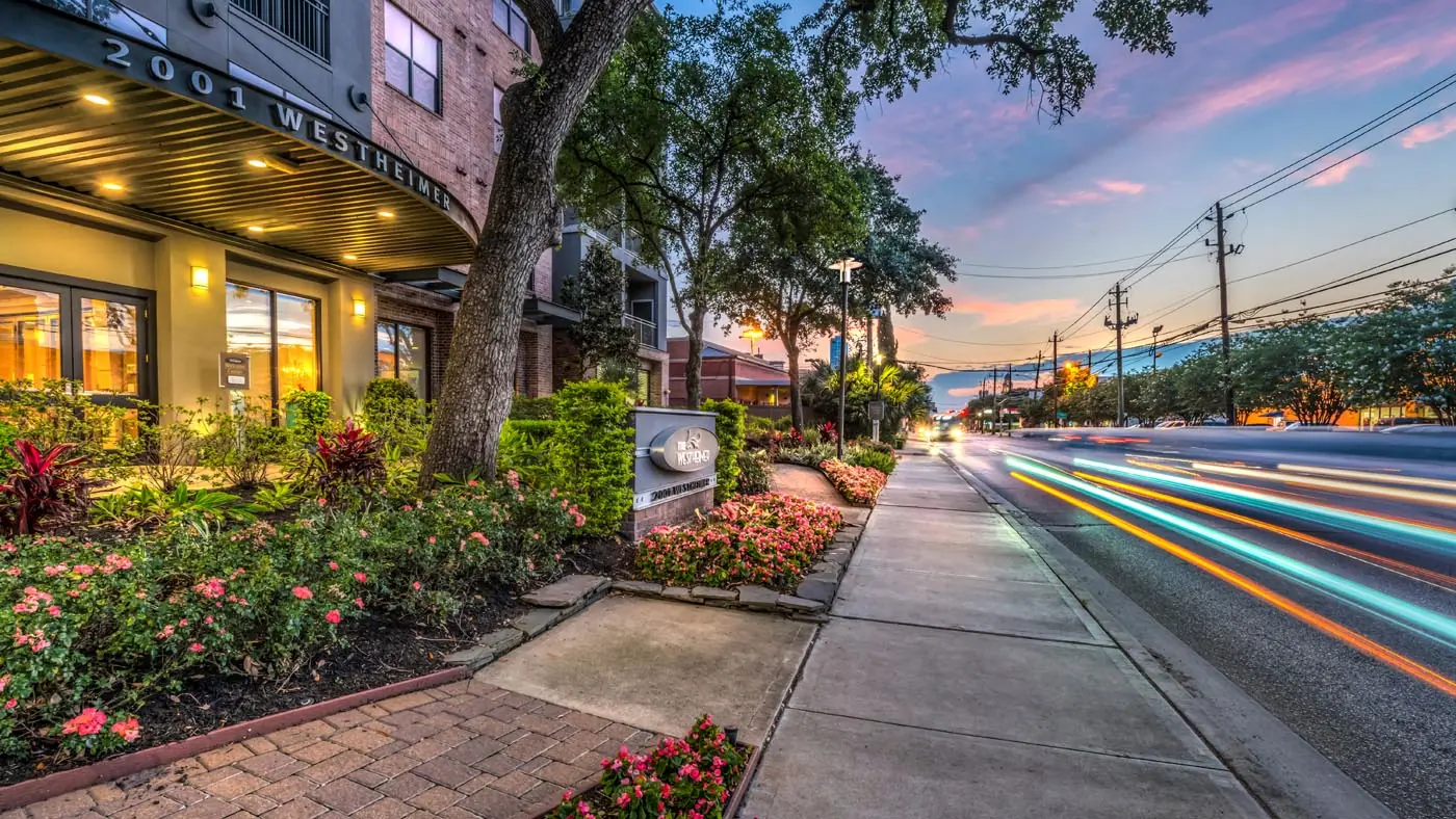 Landscaped sidewalk and signage at Westheimer Apartments along Westheimer Road in Houston, TX