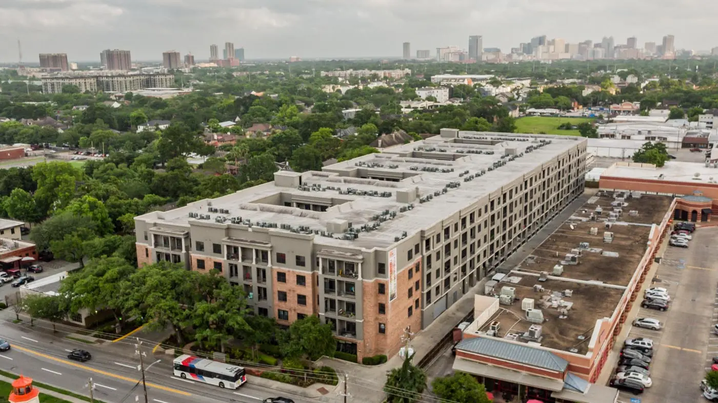 Aerial view of Westheimer Apartments in Houston, TX showing the full multifamily building footprint with the downtown skyline in the distance